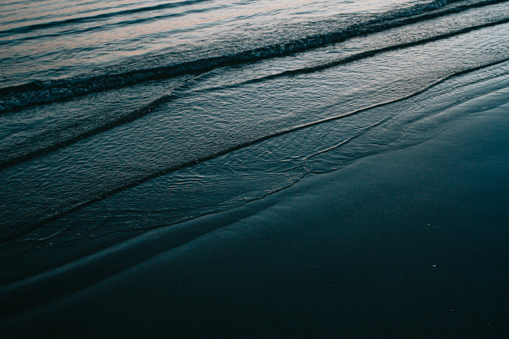 calm waves rolling on the shore at twilight