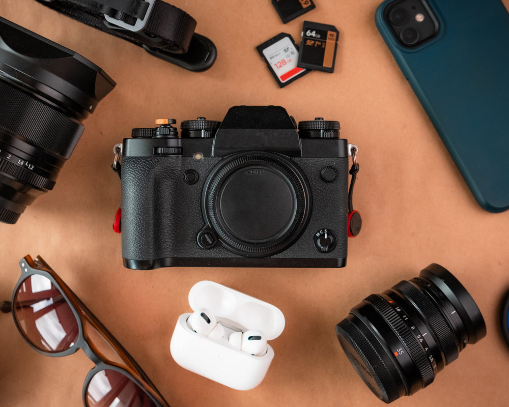 camera lays on brown table surrounded by video equipment