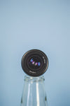 camera lens propped on a bottle