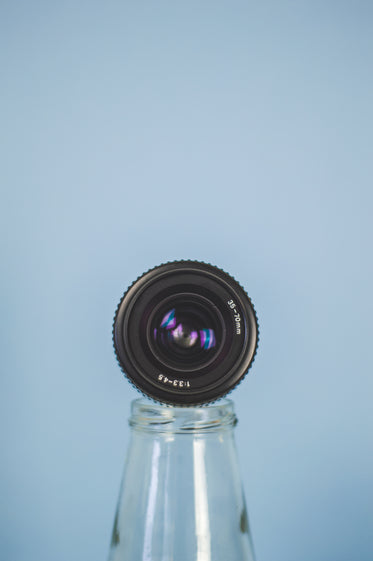 camera lens propped on a bottle