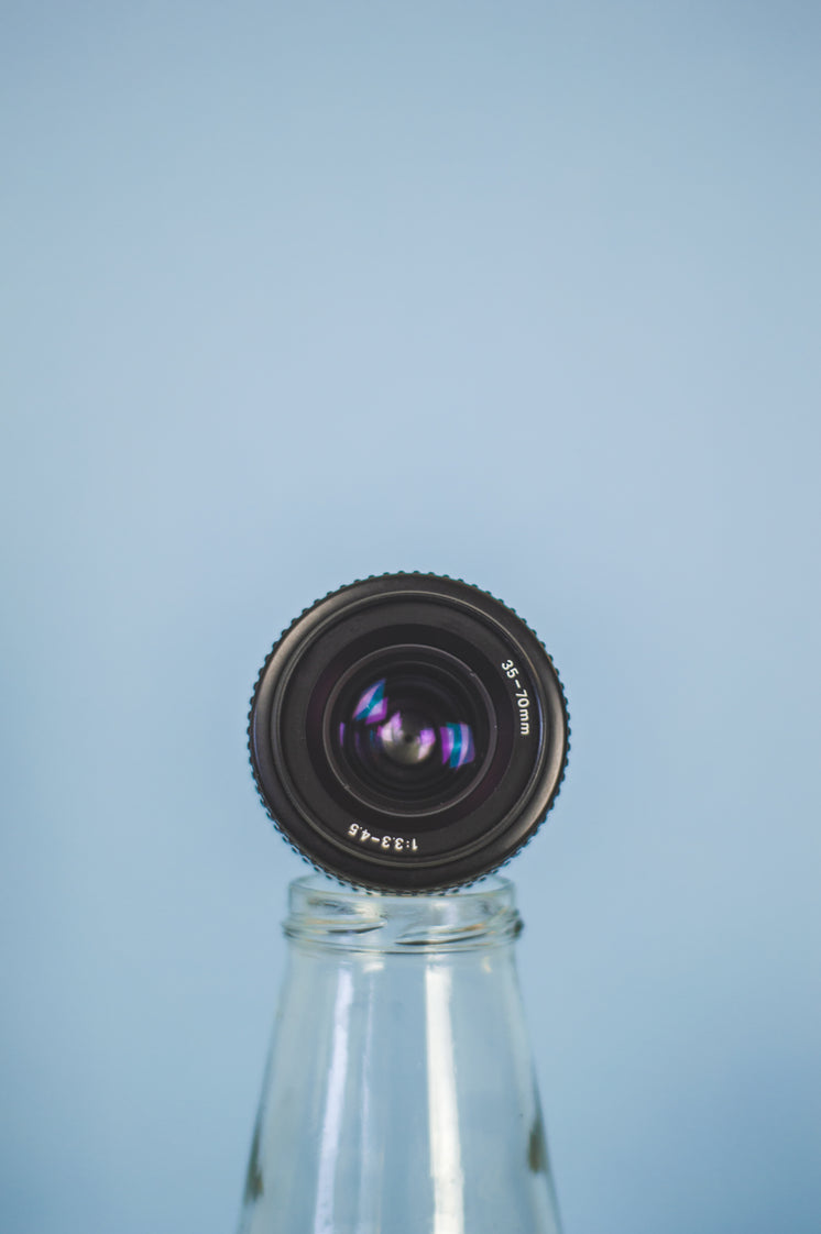 Camera Lens Propped On A Bottle