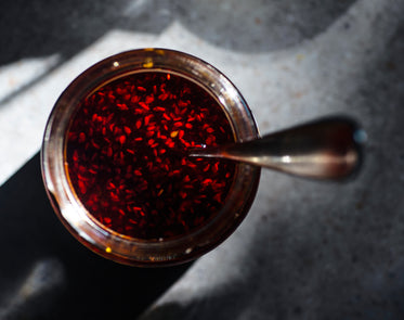 camera looks down at a glass jar filled with red sauce