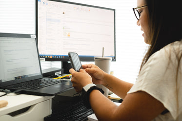 camera looks over the shoulder of person working at a desk