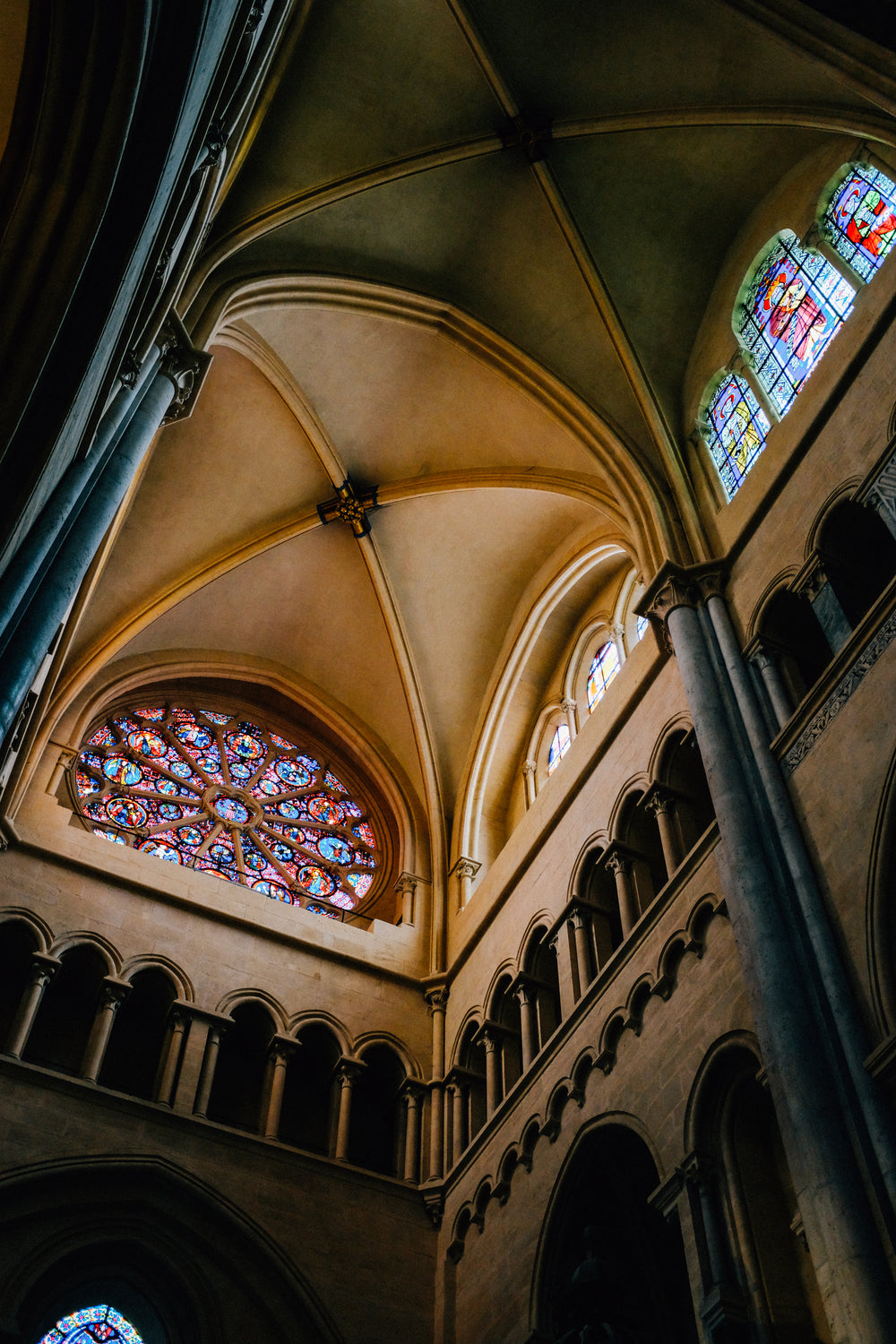 camera looks up toward large stained glass window