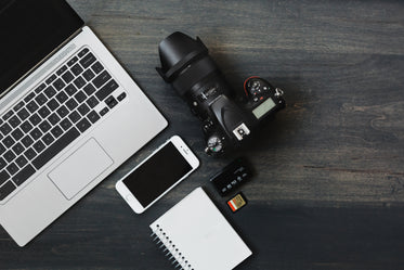 camera, phone, laptop a photographer's desk