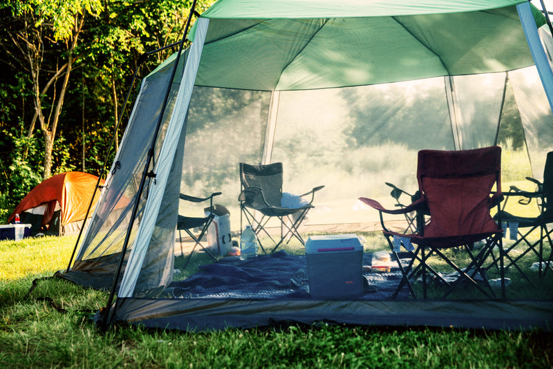 camping tents - a tent with a tent and chairs in the background