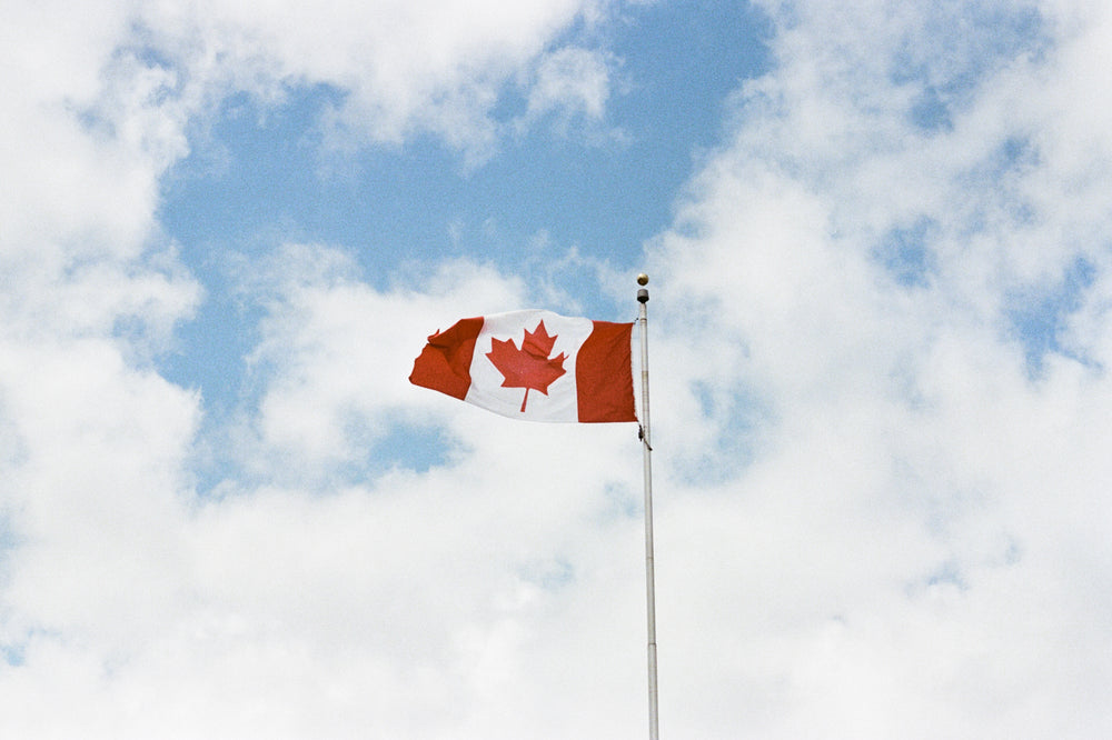 canadian flag against cloudy sky