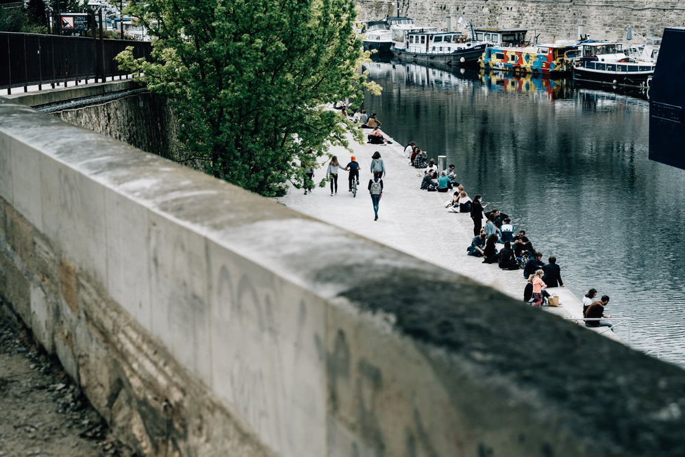 canal with people sitting and boats lining the side