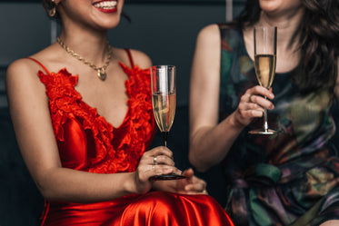 candid shot of women laughing while holding champagne