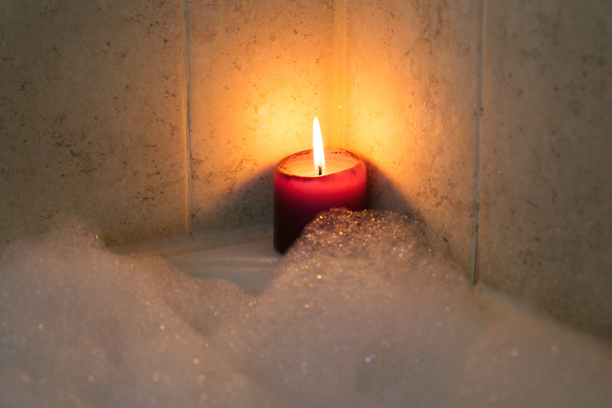 candle burning by bubble bath