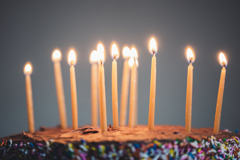 candles on an illuminated chocolate cake