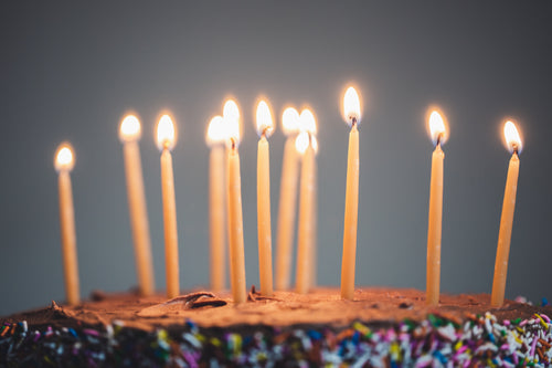 candles on an illuminated chocolate cake