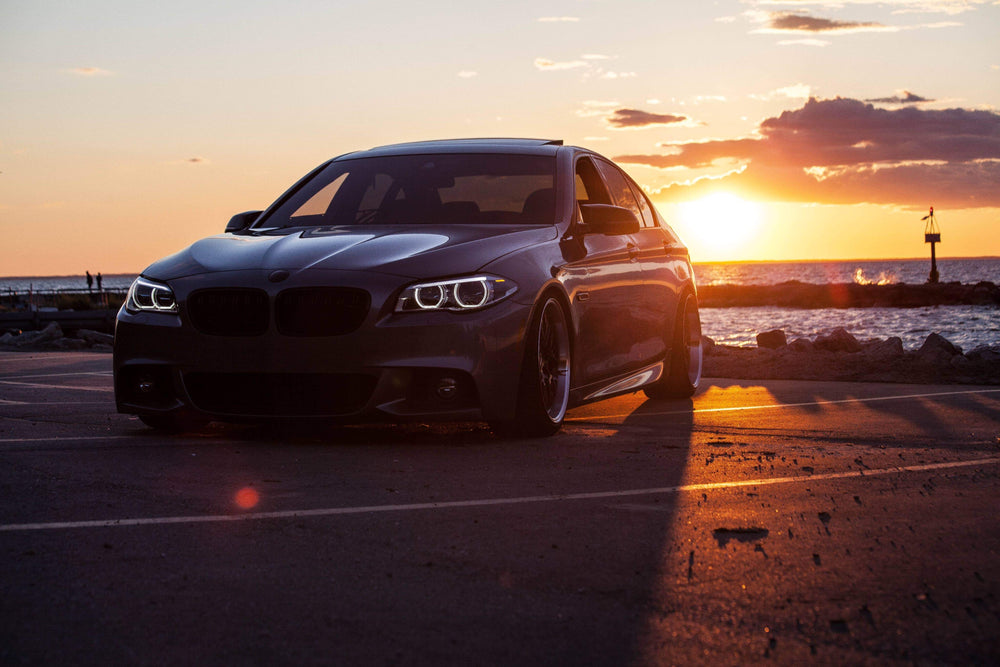 car parked by the water at sunset