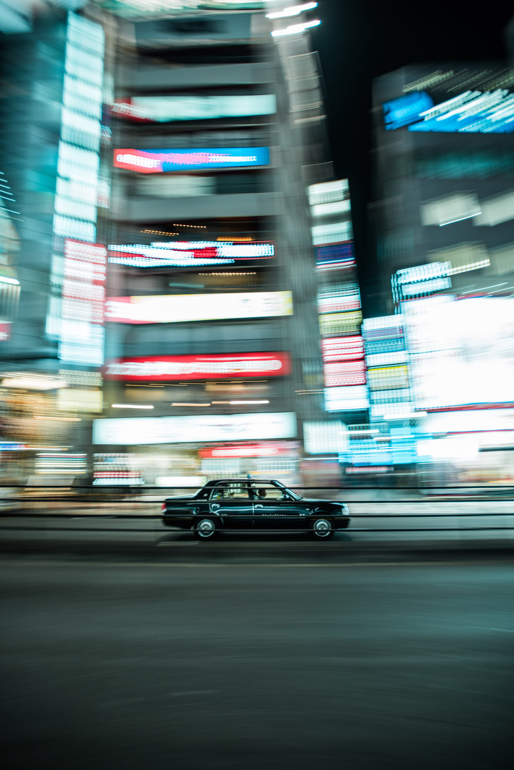 car speeding past lit buildings