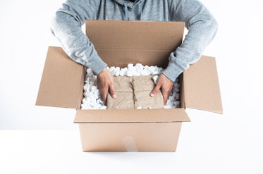 carefully placing a package into packing peanuts