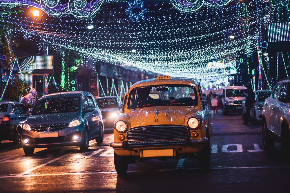 cars on a lit up city street at night