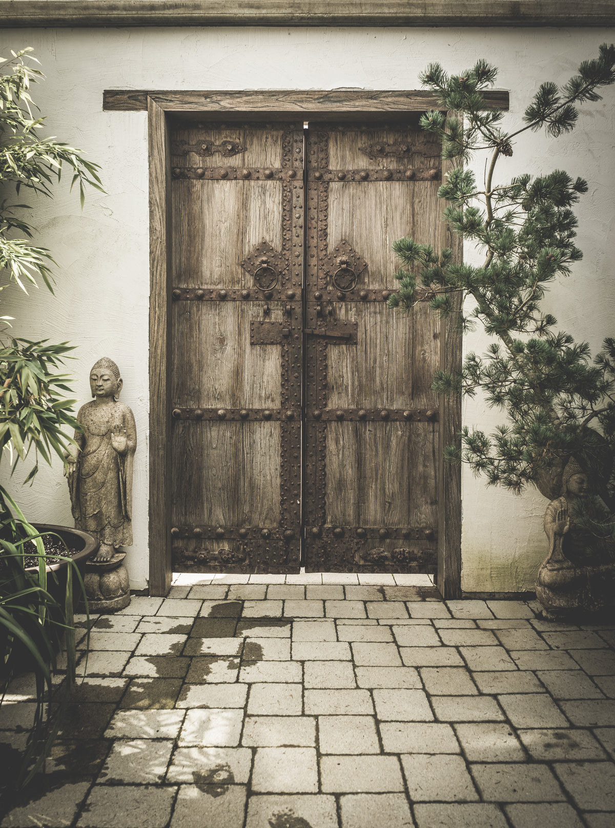 carved stone buddhas adorn ornate wooden doorway