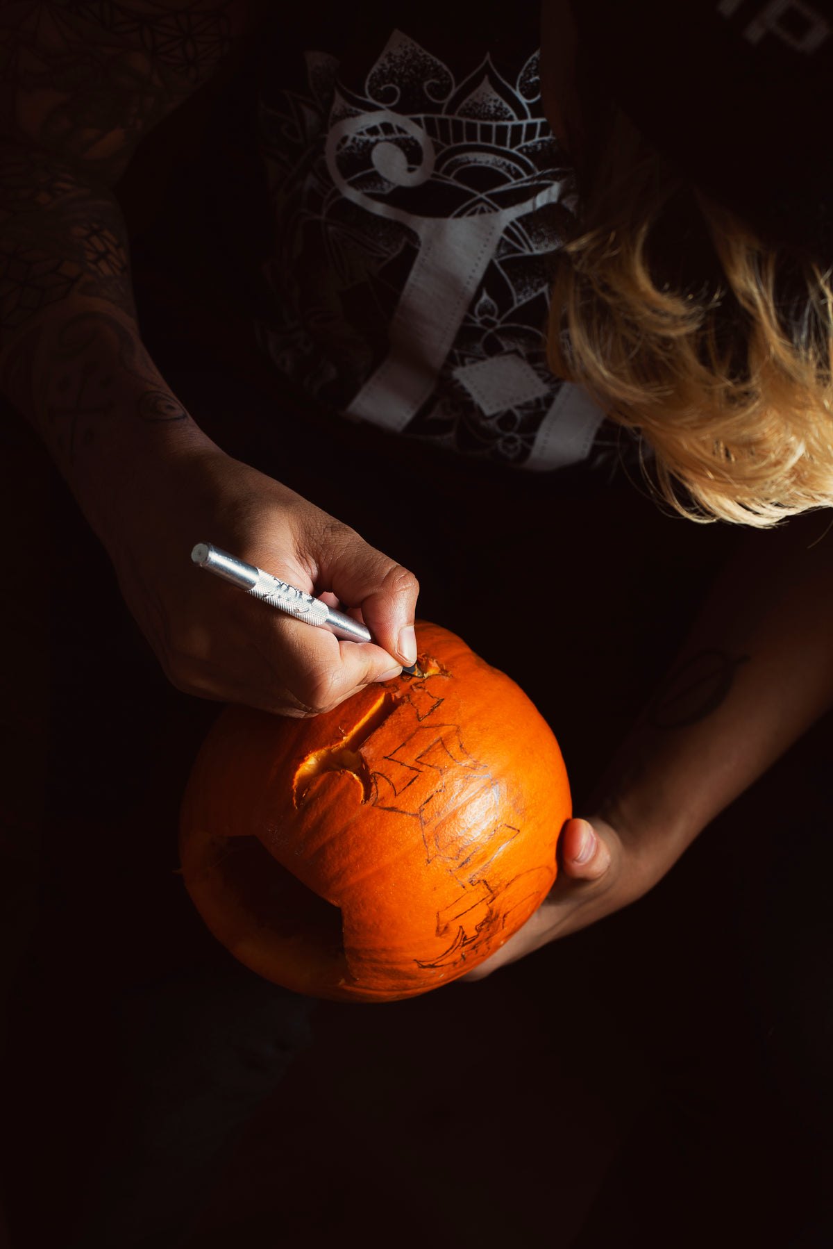carving a tiny pumpkin for halloween