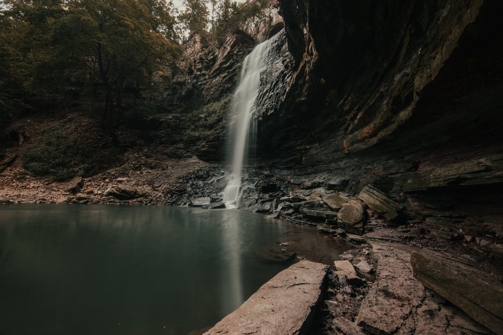 cascading waterfall beside concaved rocks