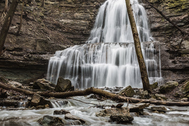 cascading waterfall cuts through layers of rocky cliffside