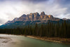 castle mountain towering over lush alberta forest