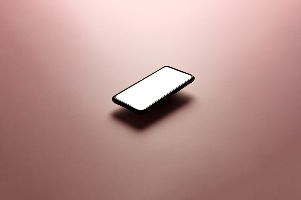 cellphone floats above a soft pink background