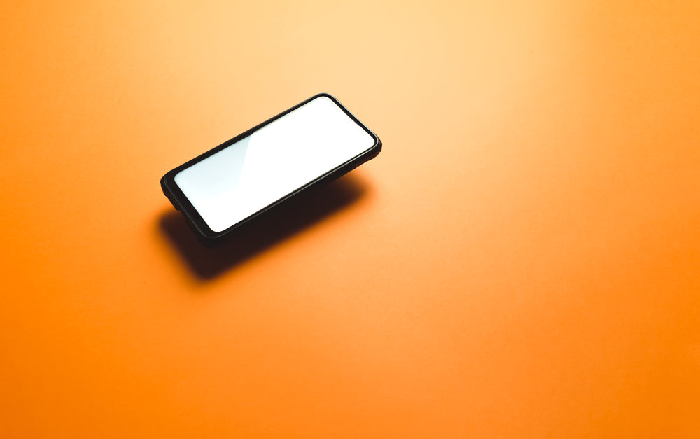 cellphone levitates above an orange background