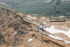 chair lift over hill with patches of snow