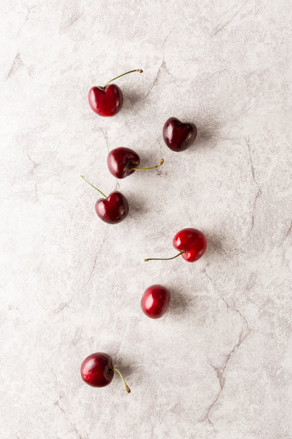 cherries scattered across marble surface