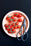 cherry tomatoes plated with kitchen scissors