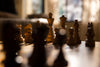 chess pieces set up on a wooden chess board