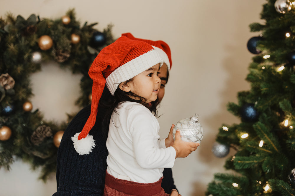 child helps decorate christmas tree