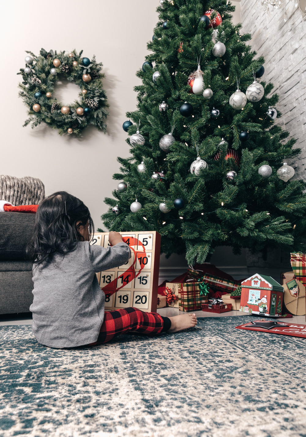 criança abre o calendário do avento na manhã de natal