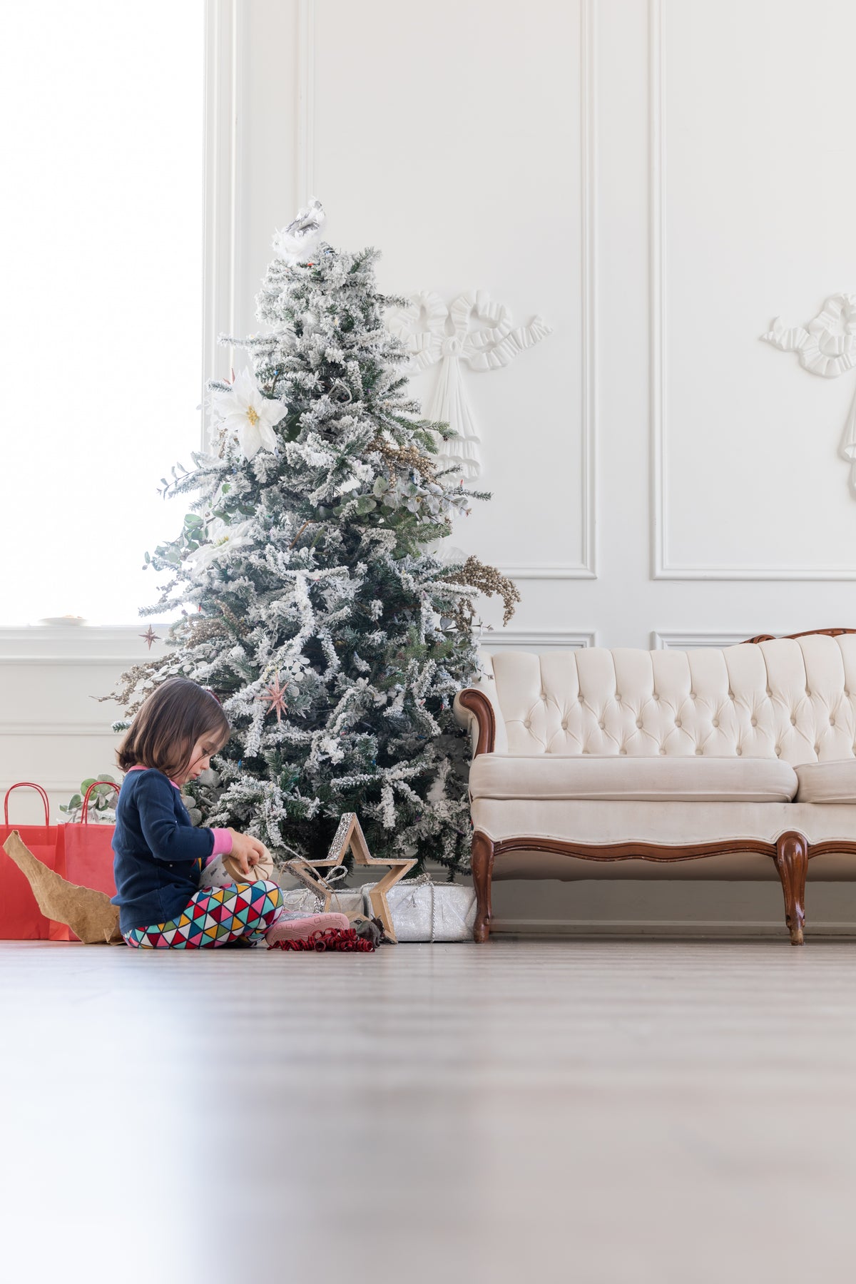 child opens gift under christmas tree