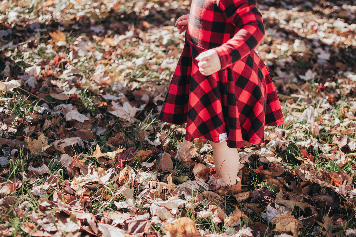 child stands in leaves