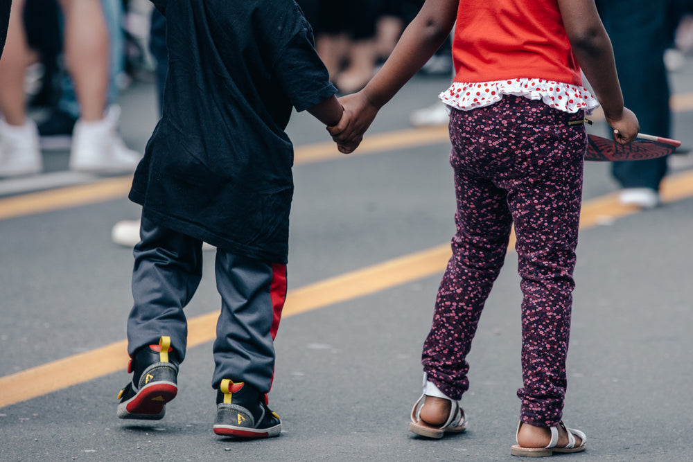 children holding hands in the street