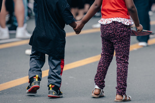 children holding hands in the street