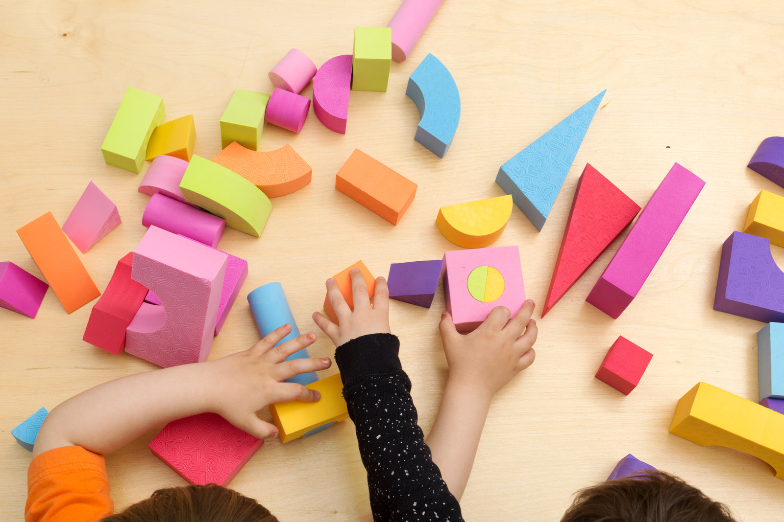 Children playing together with colourful blocks and developing social skills