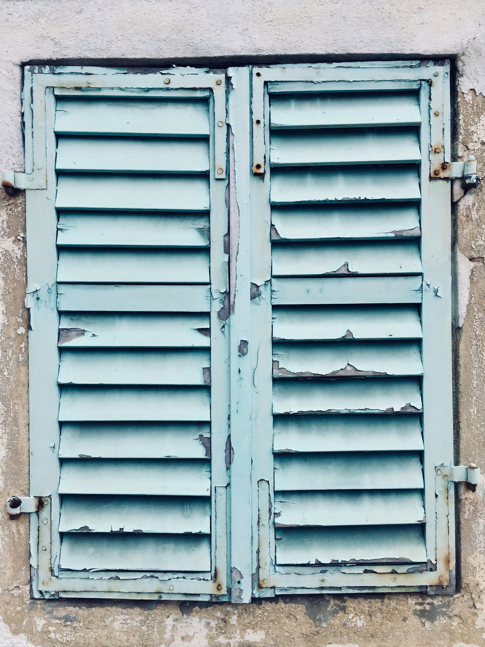 chipped blue paint on aging shutters