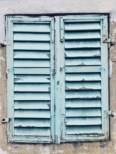 chipped blue paint on aging shutters