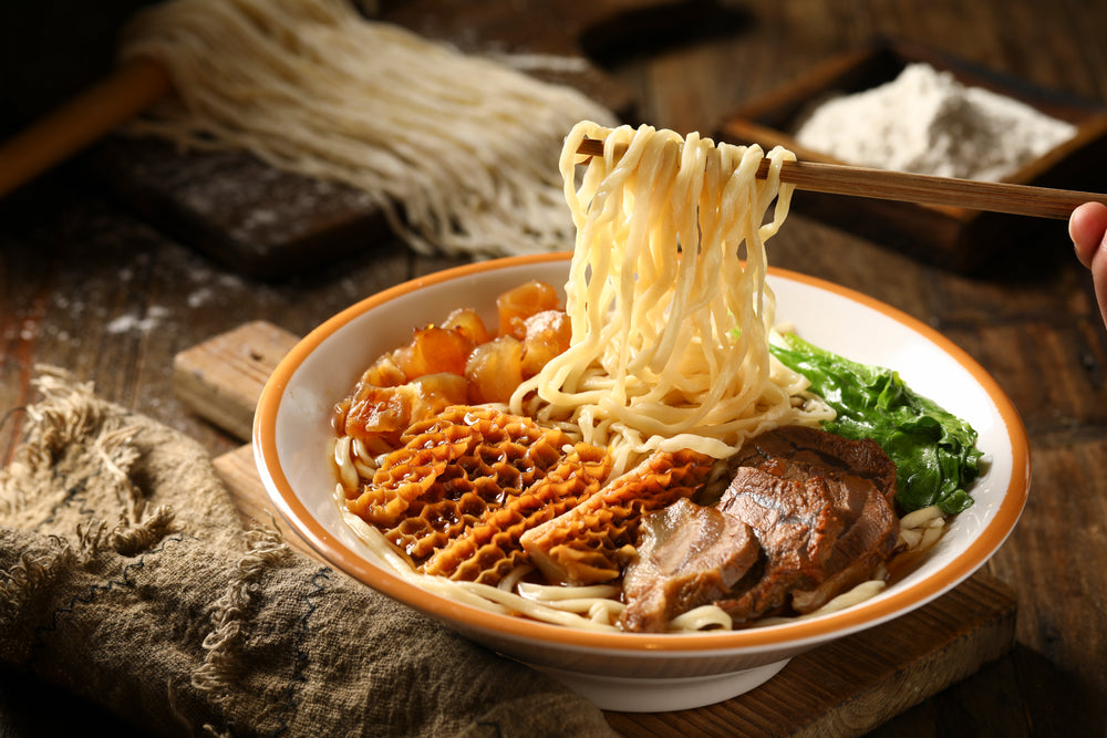 Chopsticks Held Over Bowl Of Hot Noodle Soup