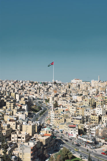 city of white square buildings with a flag in the middle