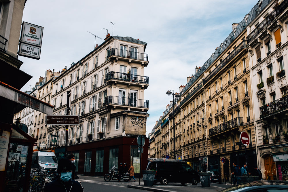 city street divides into two lined with tall buildings