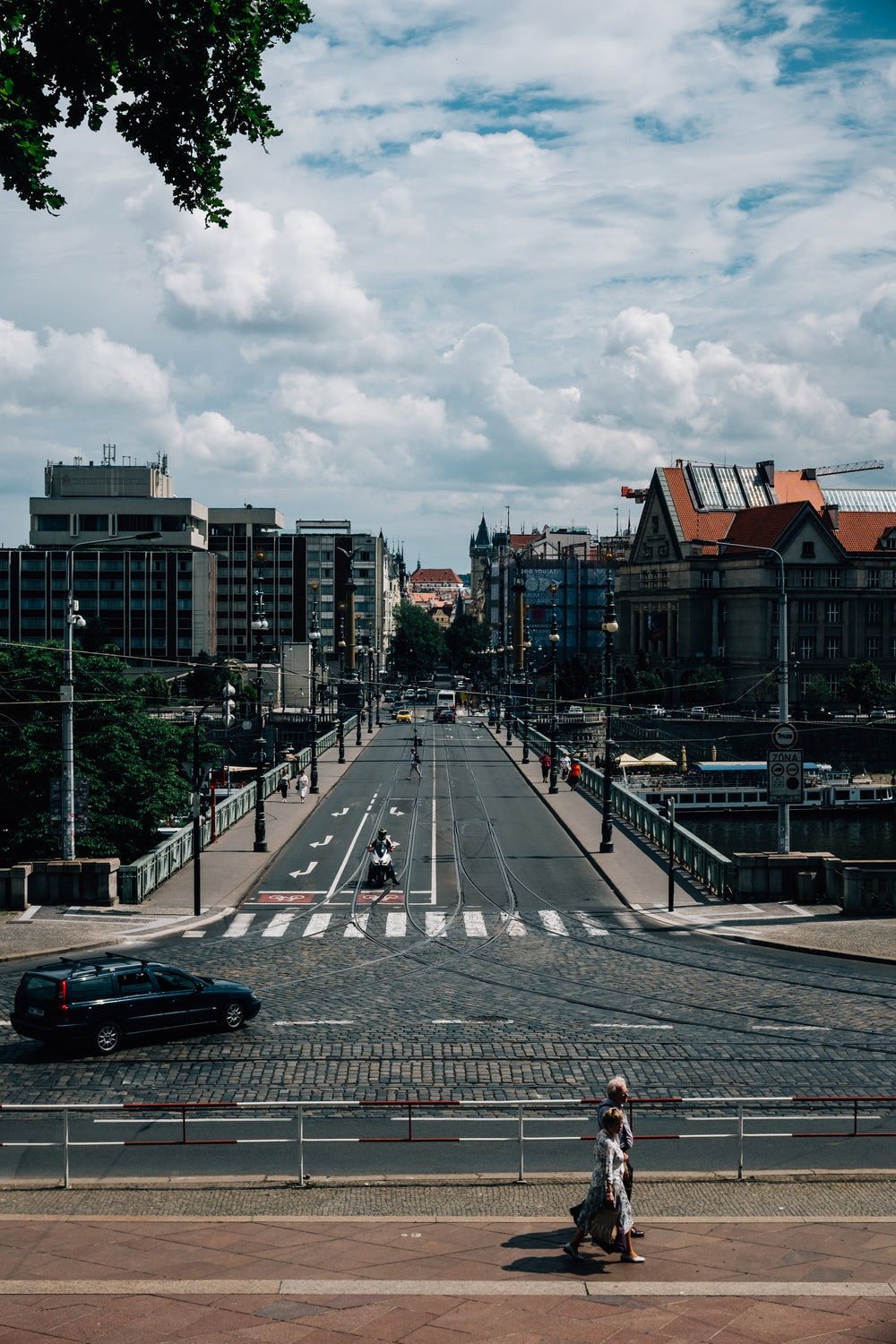 city street with cars and pedestrians in frame