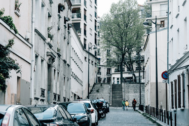 city street with cars and three pedestrians