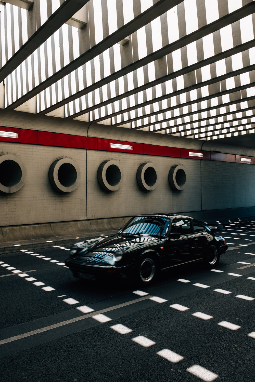 classic car races through modeern tunnel