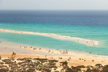 clear blue sea surrounds a small bank of sand