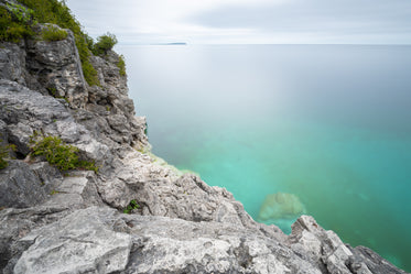 clear blue water at the bottom of rocky cliffside