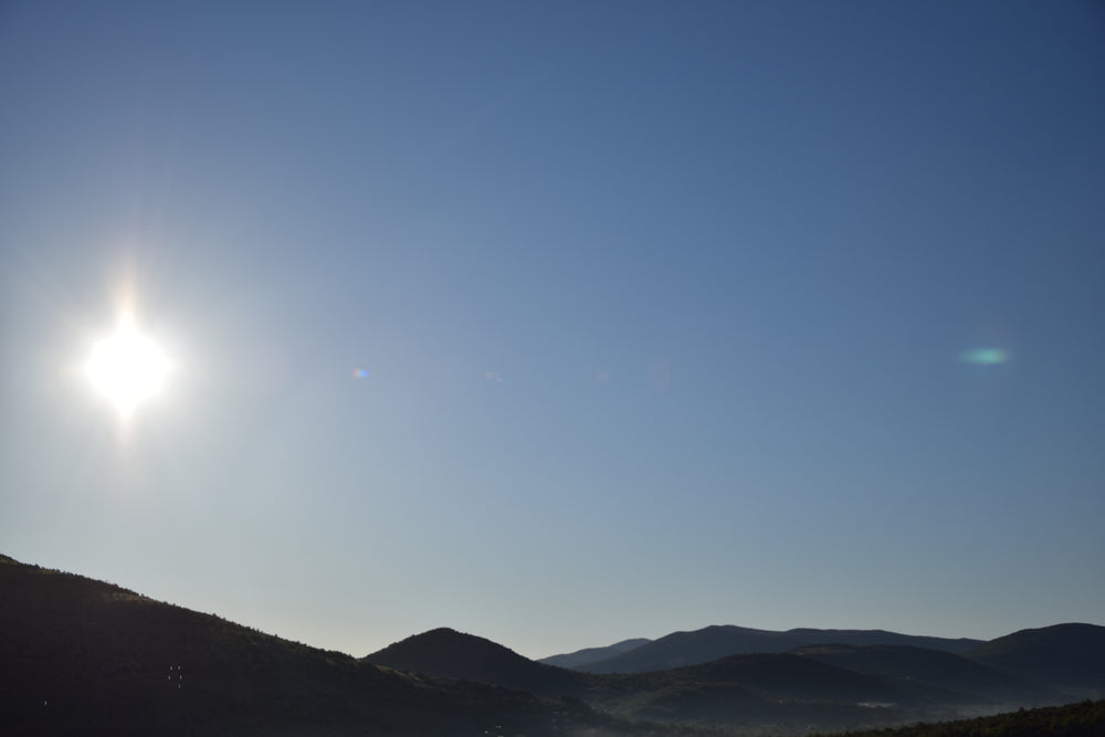 clear sky and glaring sun over hillside