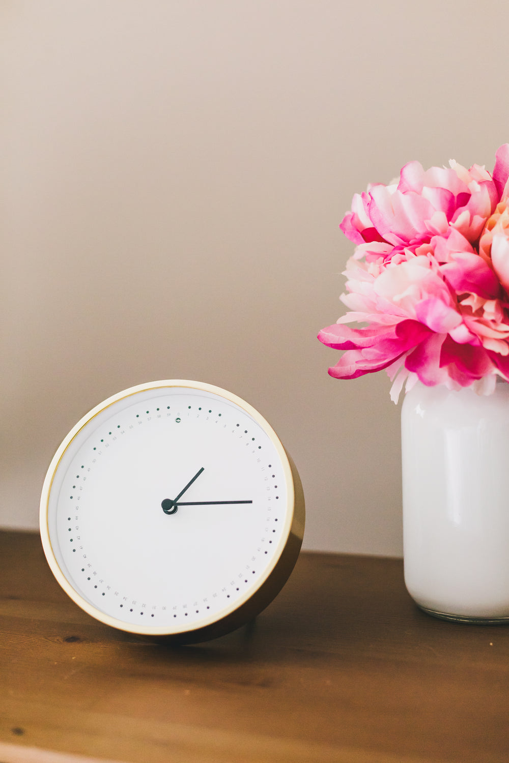 clock and flowers on side table